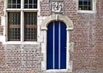 Colorful blue door from the Groot Begijnhof.  Inscription in the lintel says "Inden Berch Thabor 1649", and above that there is a low relief carving of Jesus (rising from the dead?)